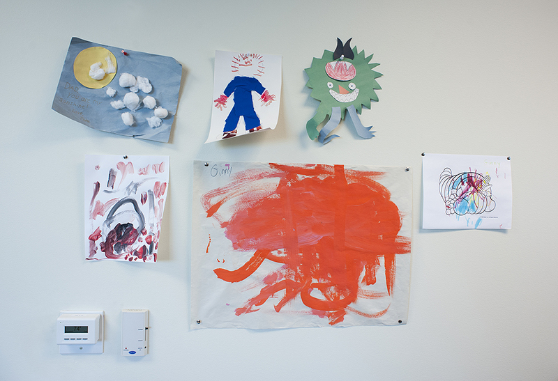 Children's artwork hangs above a desk